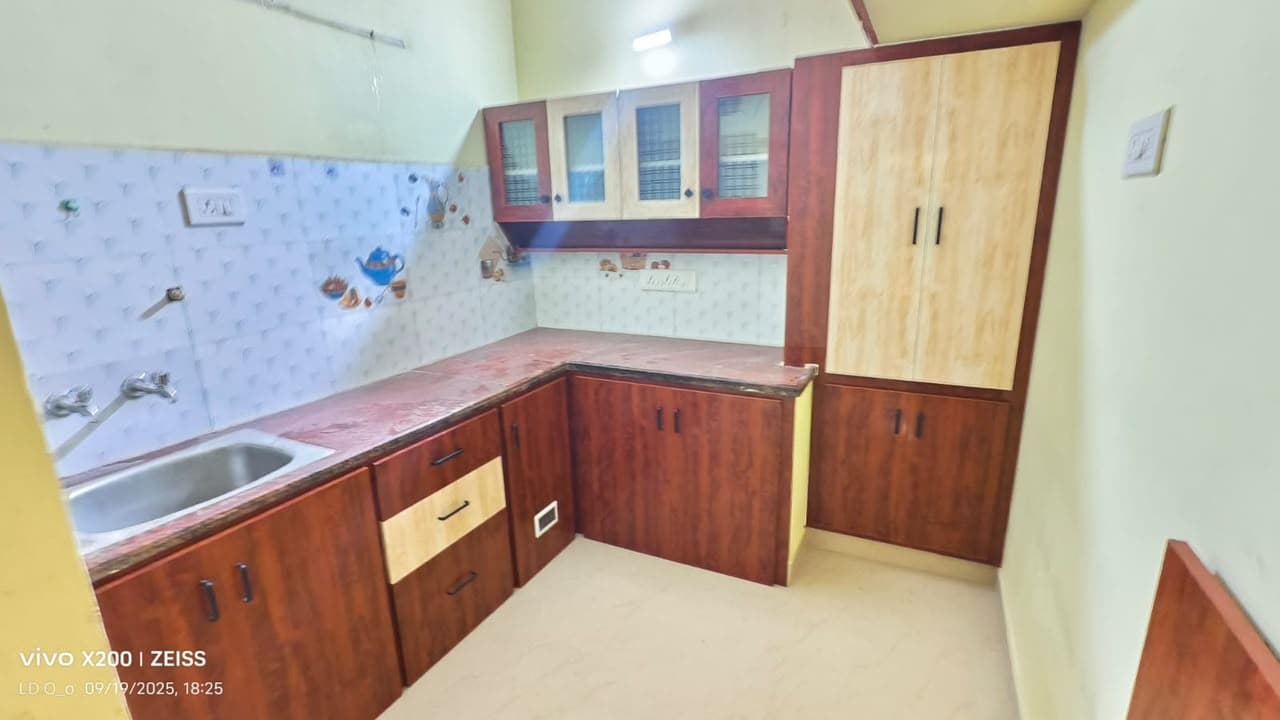 L-shaped modular kitchen with two-tone cabinets and patterned tile backsplash